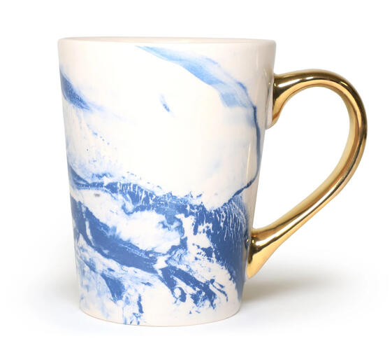 Sip your favorite beverage in style with a gold painted handle in this chic marble-effect ceramic mug. The gold-painted handle adds a touch of luxury to your daily routine.
